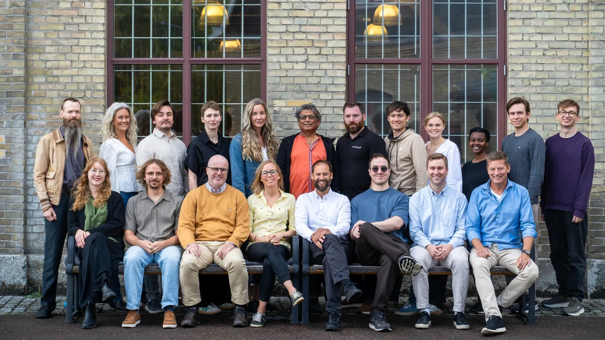 The Embedl team, seated and standing in front of a brick building